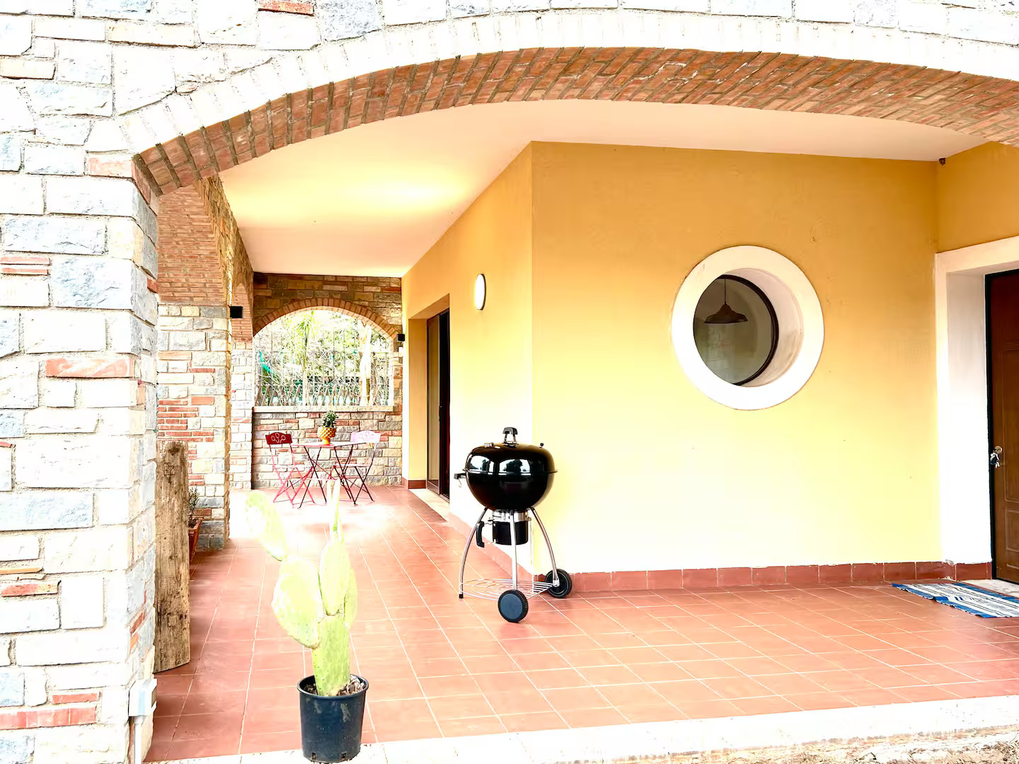 Porche cubierto con barbacoa y zona de relax en la villa